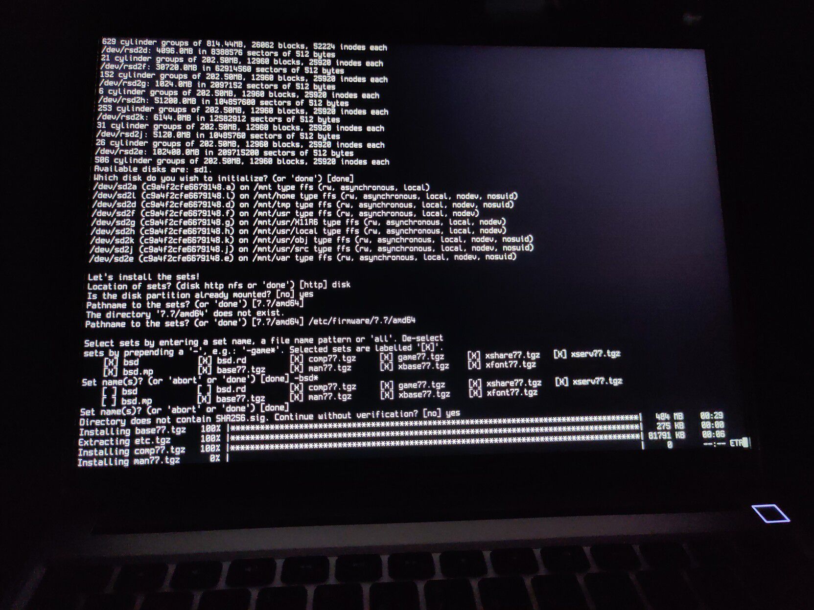 OpenBSD installer running on a laptop screen.